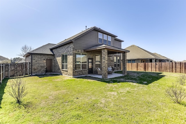 back of house with a yard, a fenced backyard, and brick siding