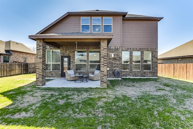 rear view of property featuring a ceiling fan, a fenced backyard, a yard, a patio area, and brick siding