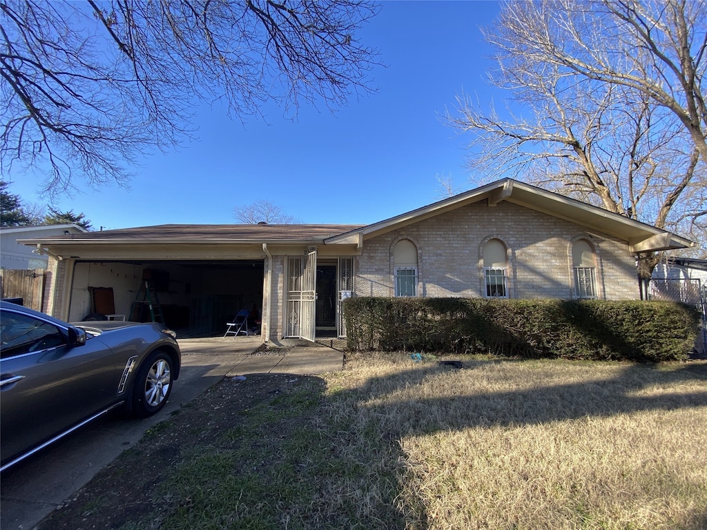 single story home featuring a garage, a front lawn, concrete driveway, and brick siding