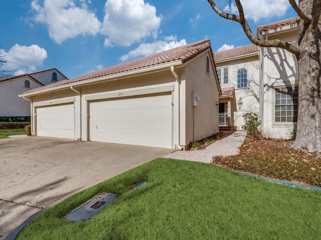 view of front of home featuring a front yard, driveway, a tiled roof, and stucco siding