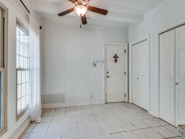 interior space featuring visible vents, ceiling fan, baseboards, and light tile patterned floors