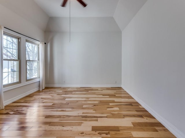 unfurnished room featuring light wood-style floors, lofted ceiling, baseboards, and a ceiling fan