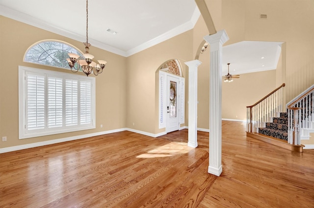 interior space featuring visible vents, stairway, wood finished floors, crown molding, and ornate columns