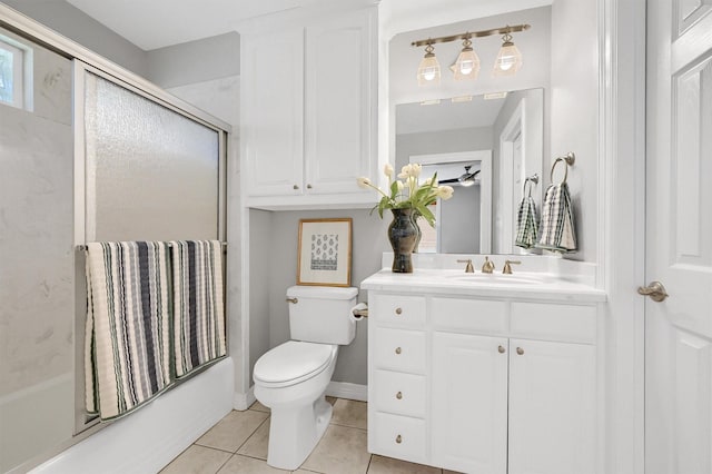 bathroom featuring baseboards, toilet, tile patterned flooring, combined bath / shower with glass door, and vanity