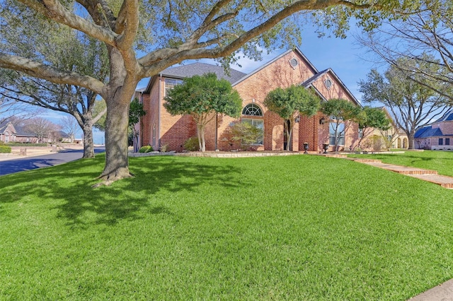 view of front of home featuring a front yard and brick siding