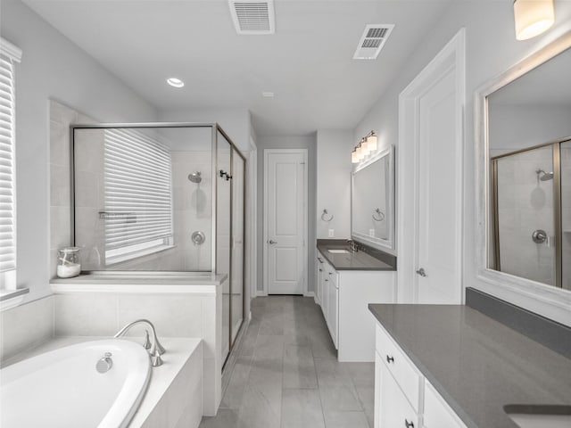 bathroom featuring a stall shower, visible vents, and a bath