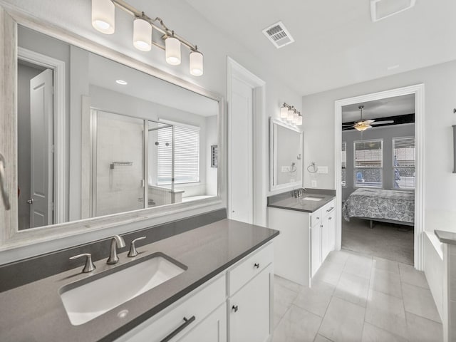 full bathroom with a shower stall, visible vents, two vanities, and a sink