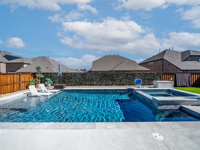 view of pool with a fenced backyard and a pool with connected hot tub