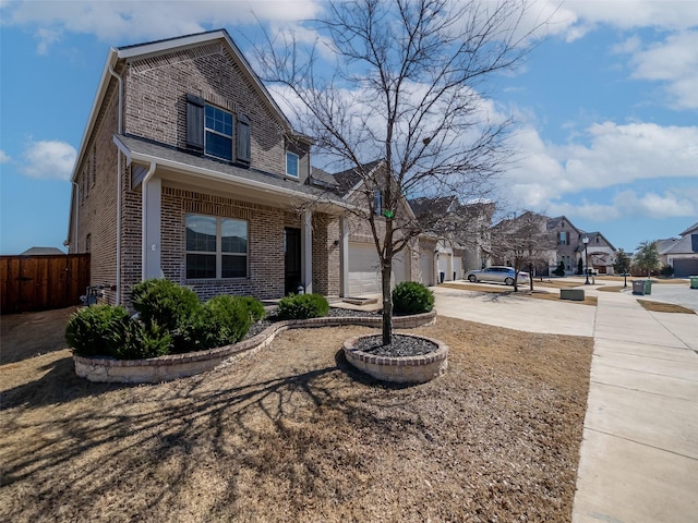 view of home's exterior with a garage, driveway, brick siding, and fence