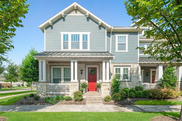 craftsman-style home with a porch, a standing seam roof, metal roof, and stone siding