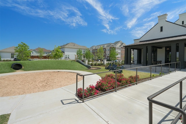 surrounding community featuring a residential view, a lawn, and playground community