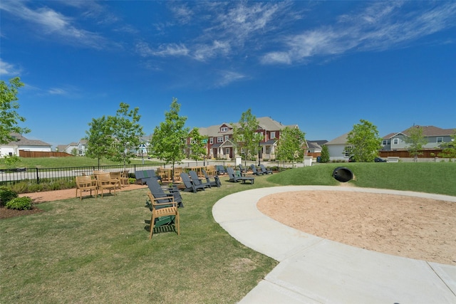 view of community featuring a lawn, fence, and a residential view