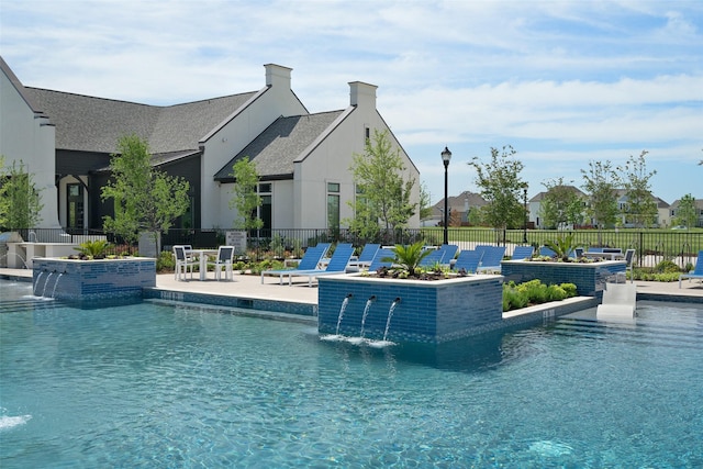 community pool with a patio area and fence