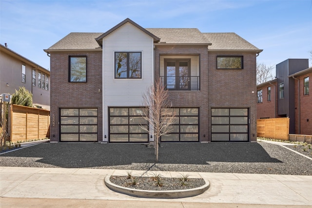 view of front of property with a garage, driveway, a shingled roof, fence, and brick siding