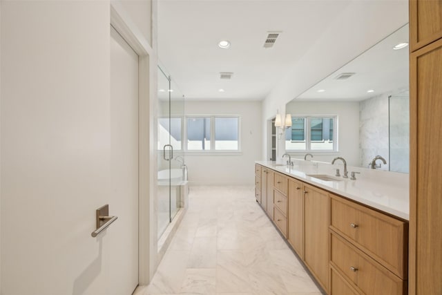 bathroom with double vanity, a shower stall, visible vents, and a sink