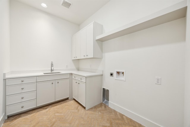 clothes washing area with visible vents, baseboards, a sink, washer hookup, and electric dryer hookup