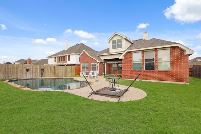 back of house with a fenced in pool, brick siding, a lawn, a patio area, and a fenced backyard