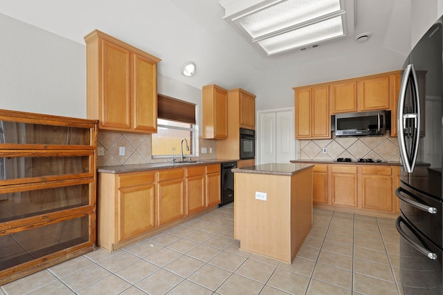 kitchen with light stone counters, a center island, light tile patterned flooring, vaulted ceiling, and black appliances