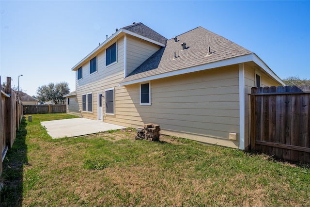 back of house featuring a patio, a yard, roof with shingles, and a fenced backyard