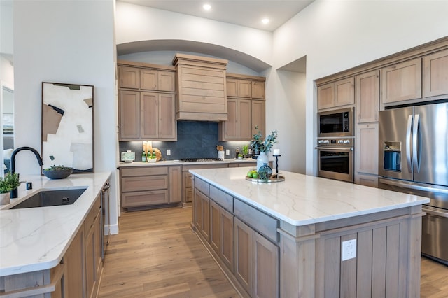 2521 Warwick Dr, Celina, TX 75009 - kitchen featuring a center island, a sink, stainless steel appliances, light wood finished floors, and backsplash
