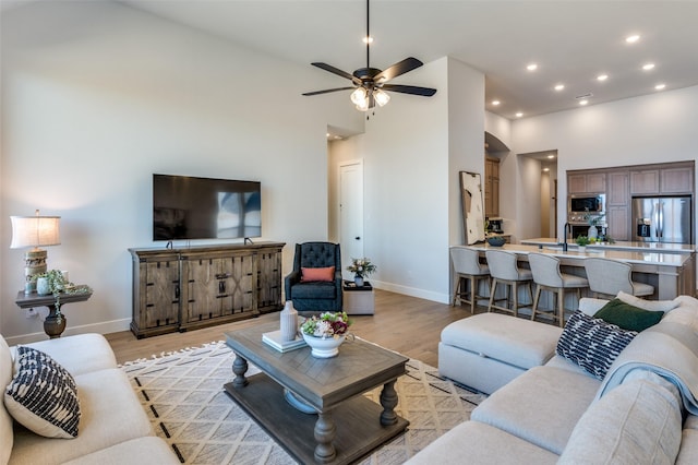 2521 Warwick Dr, Celina, TX 75009 - living area featuring light wood finished floors, a towering ceiling, baseboards, recessed lighting, and ceiling fan