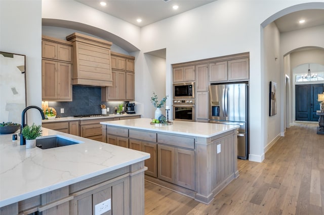 2521 Warwick Dr, Celina, TX 75009 - kitchen with light stone counters, a center island, a sink, backsplash, and appliances with stainless steel finishes