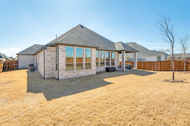 2521 Warwick Dr, Celina, TX 75009 - back of house with central AC unit, a fenced backyard, a patio area, brick siding, and roof with shingles