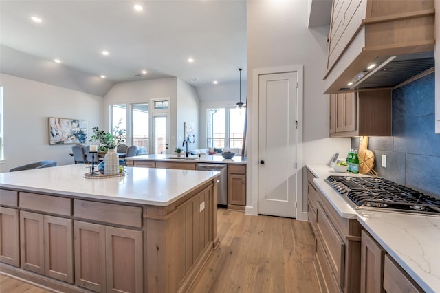 2521 Warwick Dr, Celina, TX 75009 - kitchen with wall chimney exhaust hood, a center island, light wood-style flooring, a sink, and appliances with stainless steel finishes