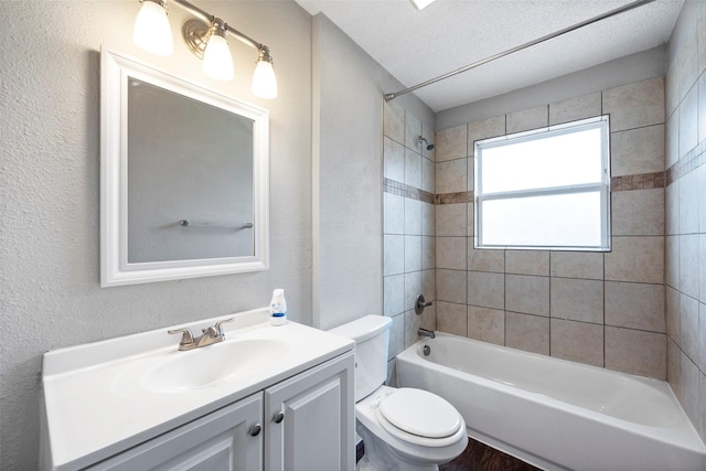 bathroom with shower / washtub combination, a textured wall, toilet, vanity, and a textured ceiling