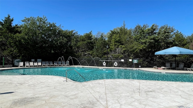 community pool with fence and a patio