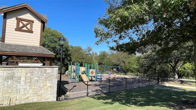 community playground featuring fence and a lawn