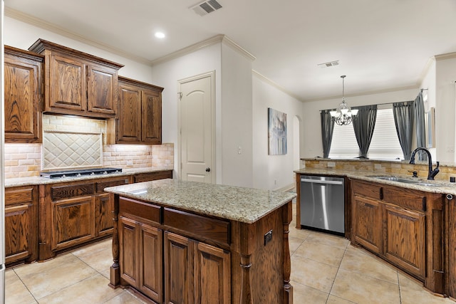 kitchen with light stone counters, visible vents, appliances with stainless steel finishes, a sink, and a kitchen island