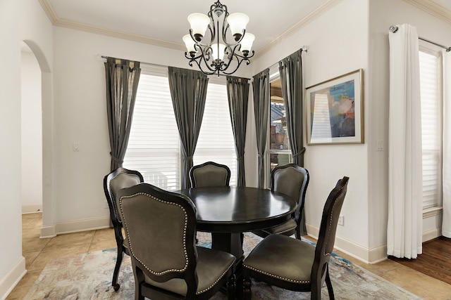 dining area featuring ornamental molding, arched walkways, plenty of natural light, and light tile patterned floors