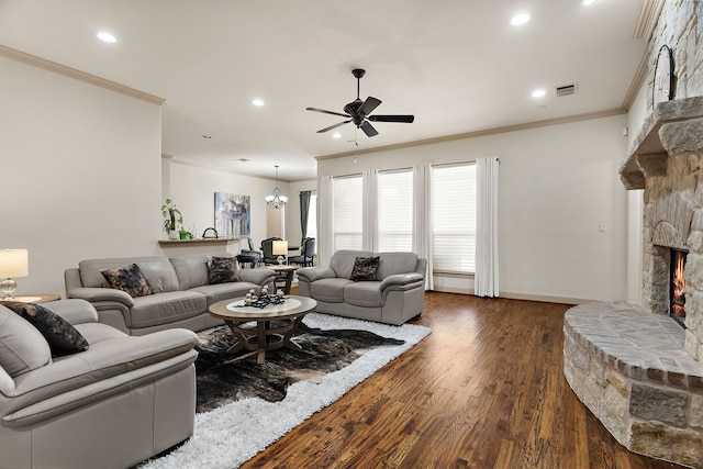 living room featuring a stone fireplace, recessed lighting, dark wood-type flooring, visible vents, and crown molding