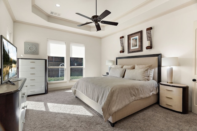 bedroom featuring a tray ceiling, visible vents, ornamental molding, a ceiling fan, and light carpet