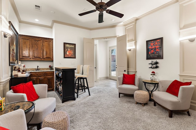 interior space featuring ceiling fan, light colored carpet, visible vents, ornamental molding, and wet bar