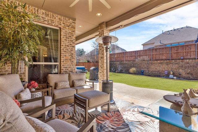 view of patio featuring an outdoor living space, a fenced backyard, and a ceiling fan