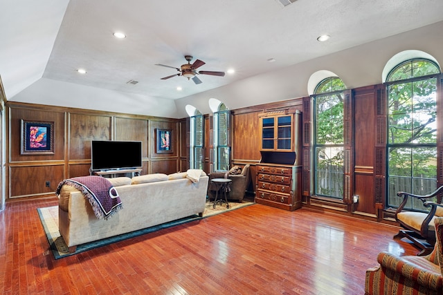 living area featuring lofted ceiling, ceiling fan, and wood finished floors