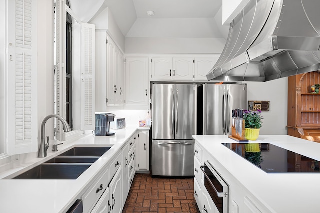 kitchen with freestanding refrigerator, black electric stovetop, a sink, and island range hood