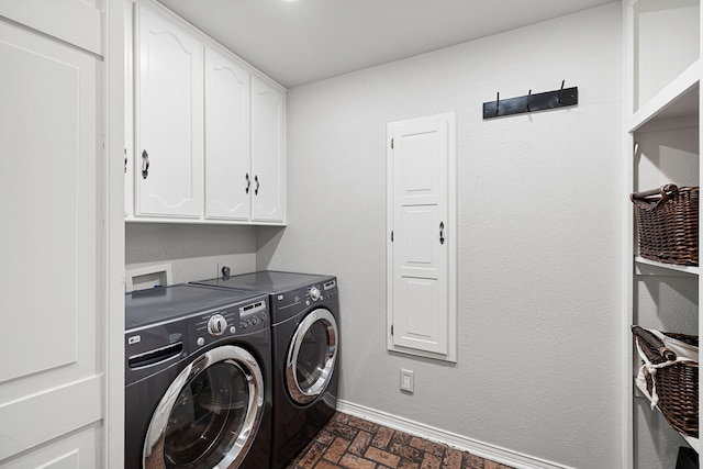 washroom with brick floor, independent washer and dryer, cabinet space, and baseboards