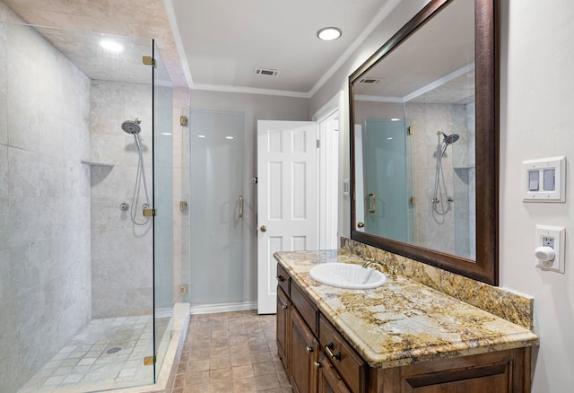 bathroom with ornamental molding, visible vents, a shower stall, and vanity