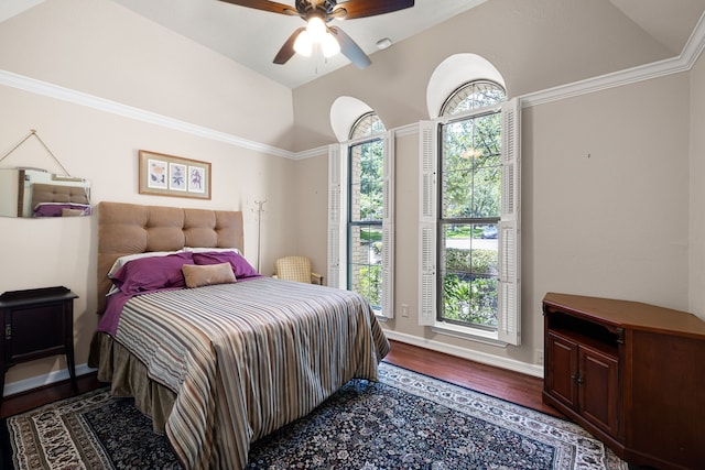 bedroom featuring lofted ceiling, dark wood-style floors, baseboards, and a ceiling fan