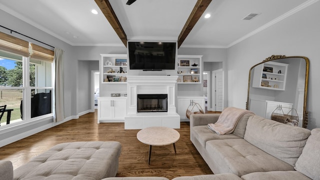 living room with beam ceiling, visible vents, ornamental molding, wood finished floors, and a tile fireplace