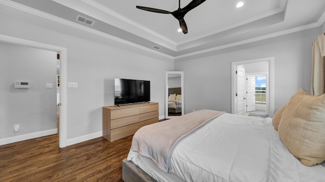 bedroom with dark wood-type flooring, a raised ceiling, crown molding, and baseboards