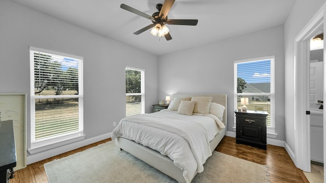 bedroom featuring multiple windows, baseboards, and dark wood-style flooring