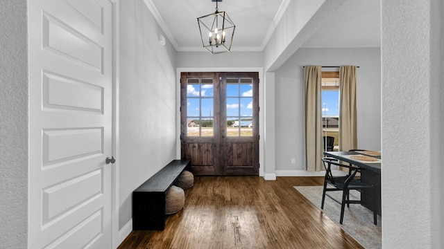 foyer entrance with crown molding, dark wood-type flooring, baseboards, french doors, and an inviting chandelier