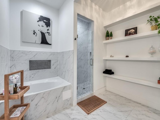 bathroom with marble finish floor, a garden tub, and a marble finish shower