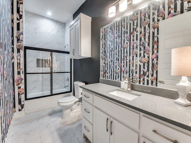 full bathroom with marble finish floor, shower / bath combination with glass door, vanity, and toilet