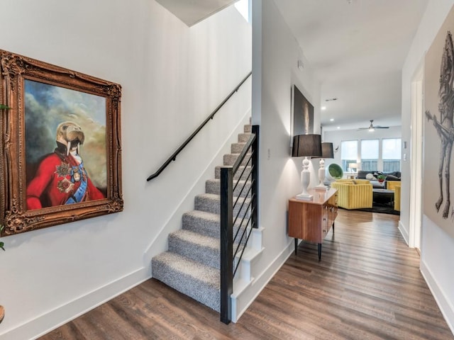 stairs with recessed lighting, wood finished floors, and baseboards