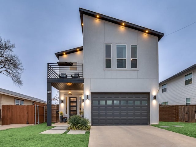 contemporary home featuring concrete driveway, an attached garage, fence, a balcony, and a front lawn